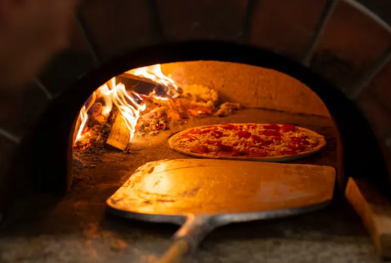 Klimatyczna sala restauracyjna Osteria Toscana przy wieczornym oświetleniu
